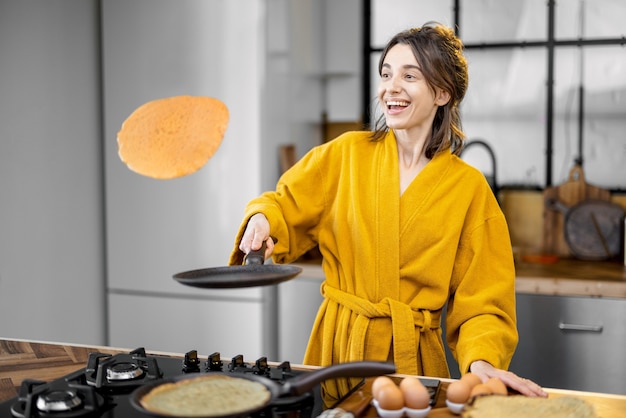 Mujer cocina panqueques para el desayuno