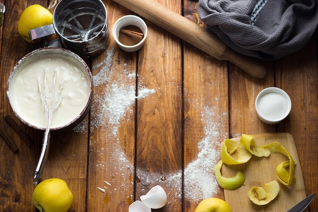 Una mujer cocina un pastel de manzana en una mesa de madera. El proceso de hacer un pastel.