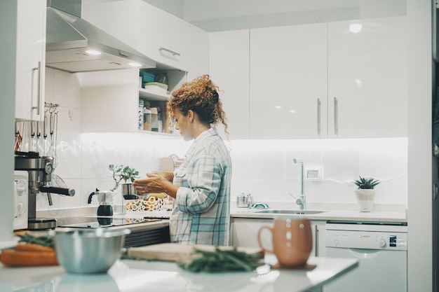 Foto una mujer cocinando en casa sola en la cocina un verdadero estilo de vida individual para mujeres independientes ama de casa preparando el almuerzo para la familia vista de una dama usando una olla y preparando comida vida interior