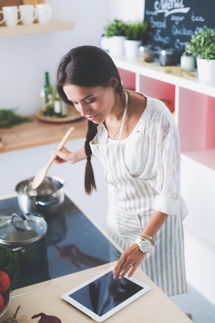 Foto mujer cocinando en la cocina con cuchara de madera mujer cocinando