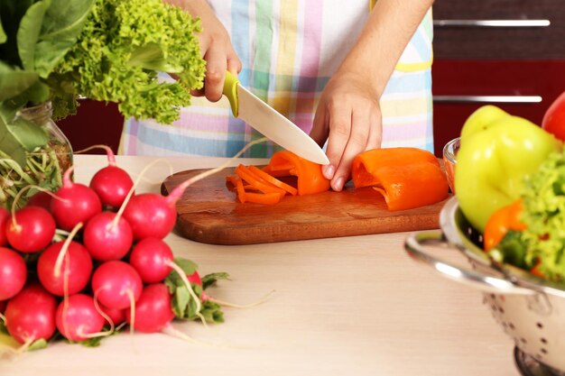 Mujer cocinando ensalada de verduras en la cocina