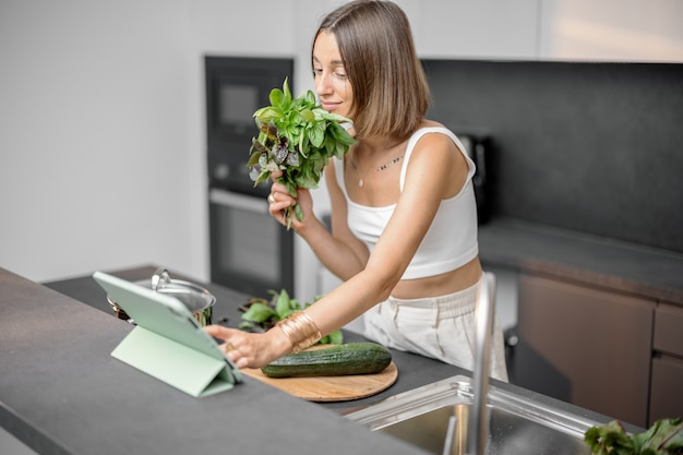 Mujer cocinando con verduras frescas y verduras en el fregadero