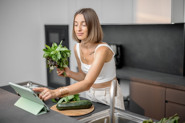 Mujer cocinando con verduras frescas y verduras en el fregadero