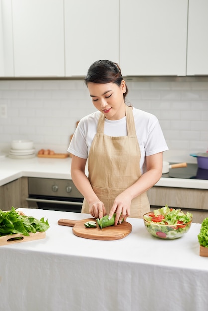 Mujer cocinera corta verduras en la cocina