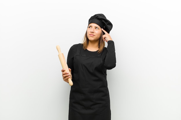 Foto mujer cocinera que parece concentrada y piensa mucho en una idea, imaginando una solución a un desafío o problema