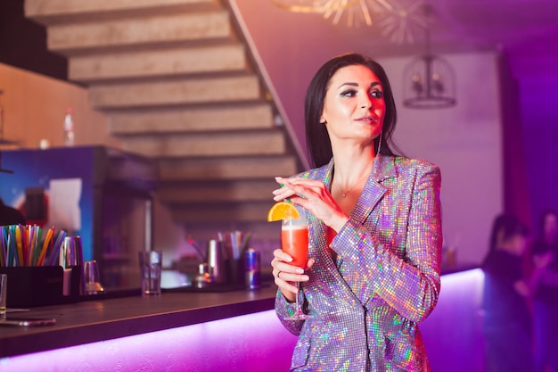 Mujer con cóctel en el bar.