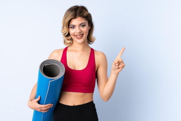 Mujer con colchoneta deportiva en estudio