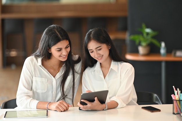 Mujer colega que trabaja con tableta digital en el lugar de trabajo