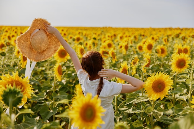 Mujer con coletas en un campo de estilo de vida de girasoles Hora de verano Foto de alta calidad