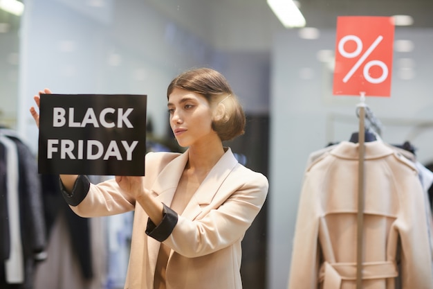 Mujer colgando viernes negro firmar en la tienda