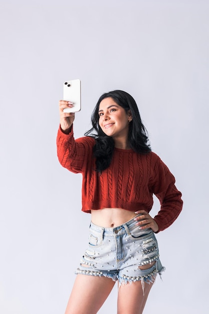 Mujer colombiana joven que usa su teléfono para tomar fotografías