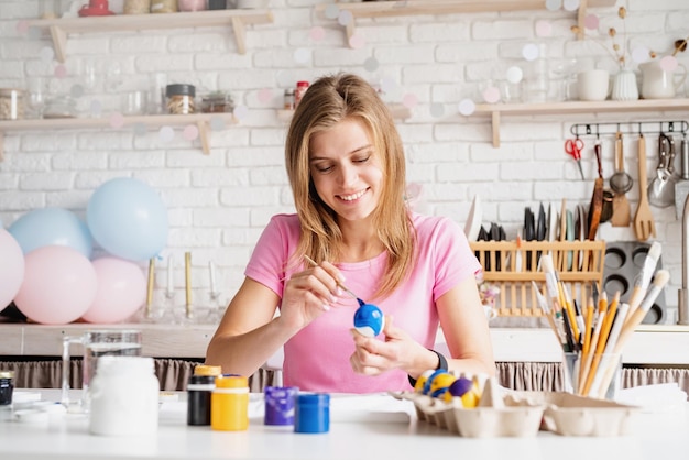 Mujer coloreando huevos de Pascua en la cocina