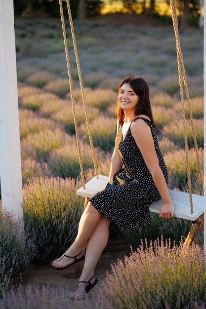 Mujer en un columpio de cuerda en un campo de lavanda