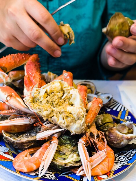 Foto la mujer come mariscos en un restaurante local de pescado