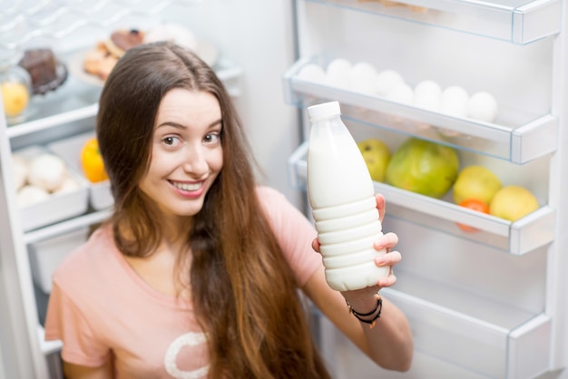 Mujer con comida cerca del refrigerador