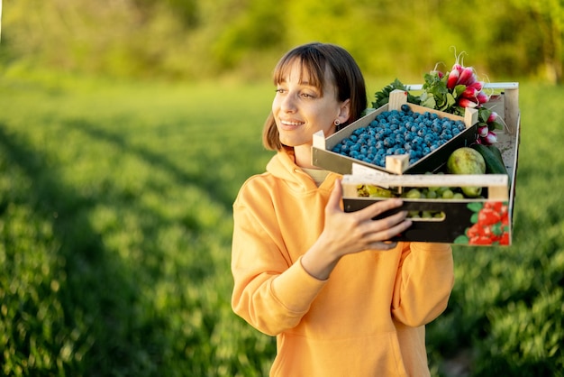 Mujer con comida fresca en tierras de cultivo