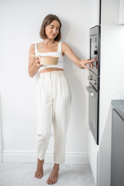 Mujer con comida para llevar en la cocina moderna en casa