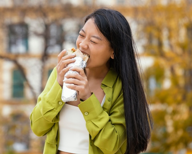 Foto mujer comiendo comida de la calle