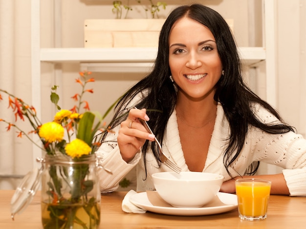 Mujer comiendo ensalada en casa