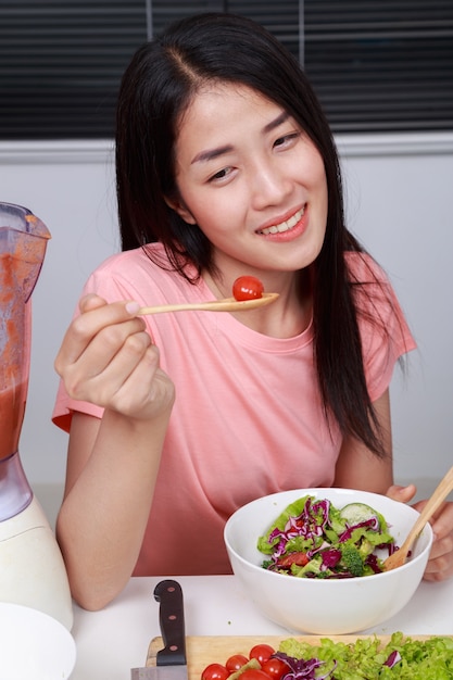 mujer comiendo ensalada en la cocina