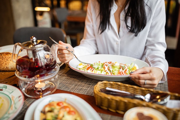 mujer comiendo ensalada saludable en un restaurante