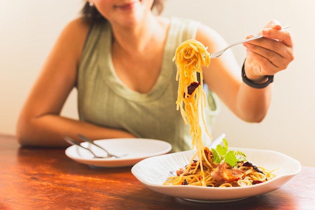 Foto mujer comiendo espaguetis con un amigo en el restaurante