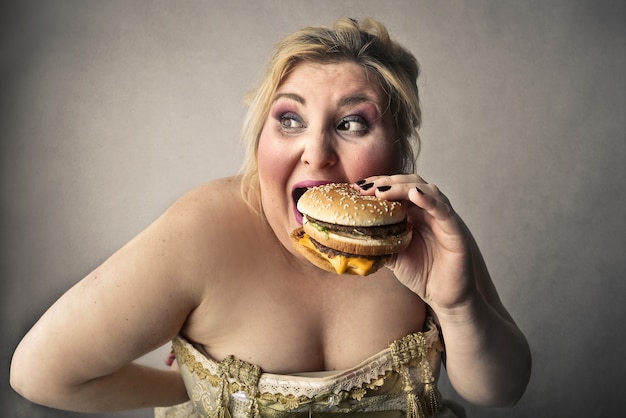 Foto mujer comiendo hamburguesa