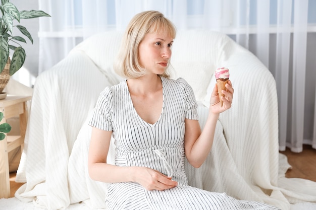 Mujer comiendo helado con fondo de sala de estar en casa. Chica mujer disfruta comiendo y hambriento concepto.