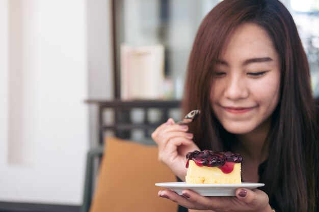 mujer comiendo pastel de queso de arándanos