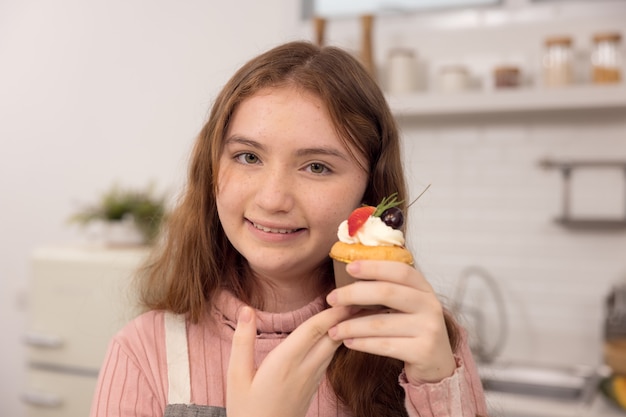 Mujer comiendo pastel en un retrato de primer plano de una maravillosa linda interesante atractiva mujer astuta hambrienta alegre sosteniendo en sus manos tortas.