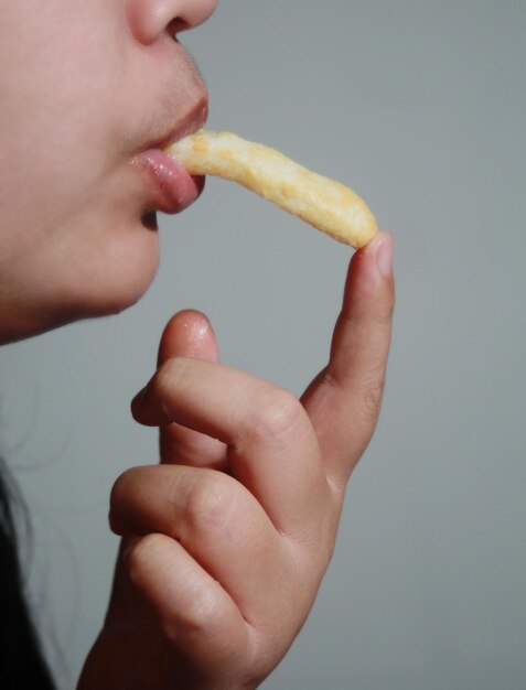 Mujer comiendo pasteles crujientes Es una comida callejera popular que es deliciosa