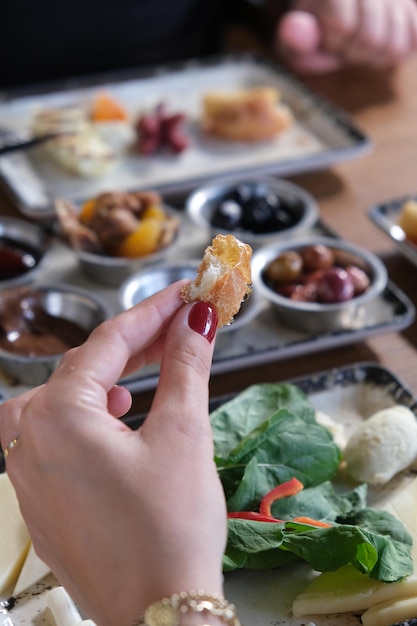 Foto una mujer está comiendo un pollo frito con un esmalte de uñas rojo