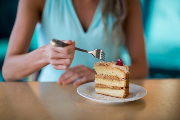 Mujer comiendo postre en café