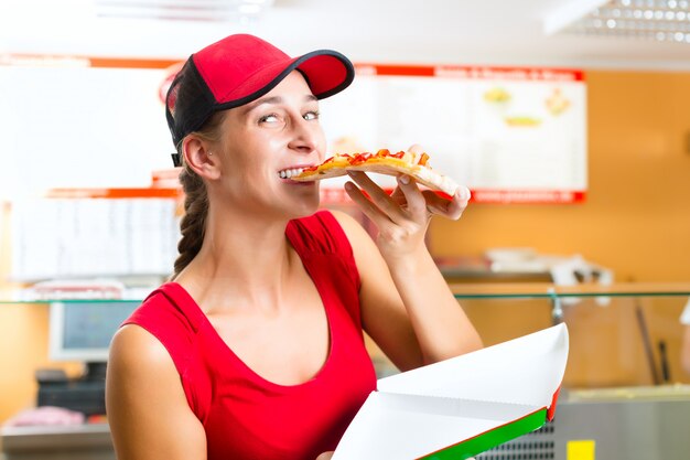 Mujer comiendo una rebanada de pizza