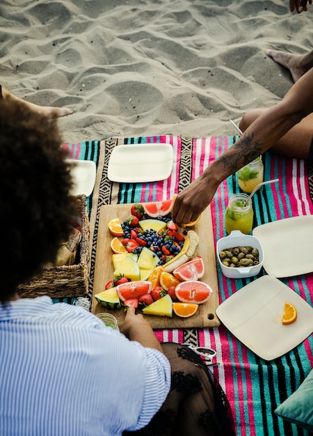 Foto mujer comiendo un sandwich en la playa