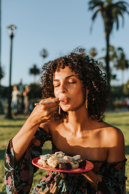 Mujer comiendo sushi en el parque