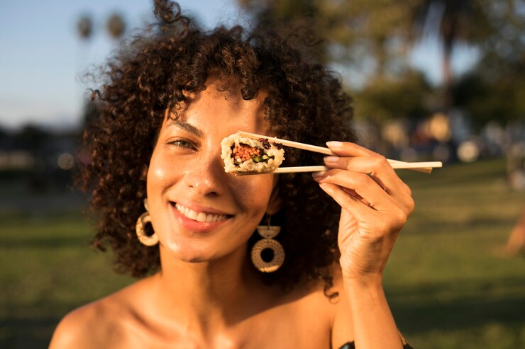 Mujer comiendo sushi en el parque