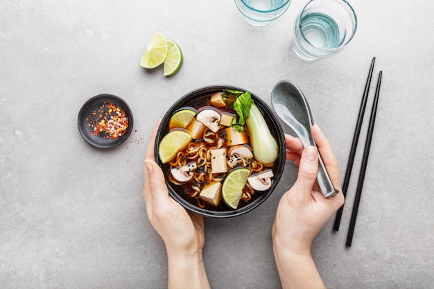 Mujer comiendo tofu asiática sopa vegetariana en un tazón