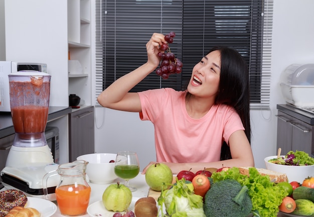 mujer comiendo uvas en la cocina