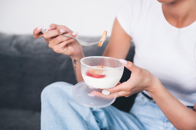 Una mujer comiendo yogur con una cuchara.