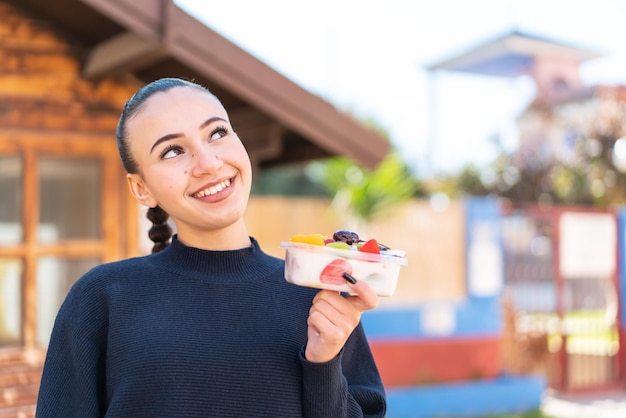 Una mujer comiendo un yogur de un recipiente.