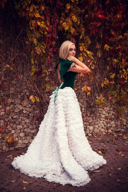 Una mujer como una princesa con un vestido vintage en el parque de las hadas