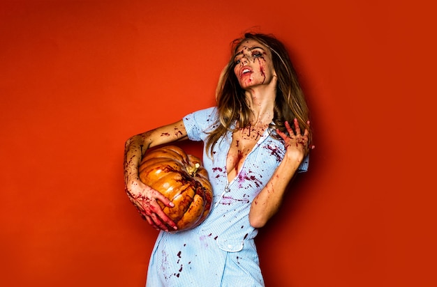 Mujer como vampiro sexy concepto de halloween asustadiza chica zombie sangrienta con calabaza mujer con sangre roja ...