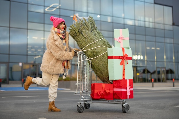 Mujer compra árbol de navidad y regalos en centro comercial