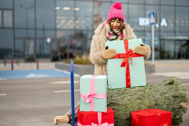Mujer compra árbol de navidad y regalos en centro comercial