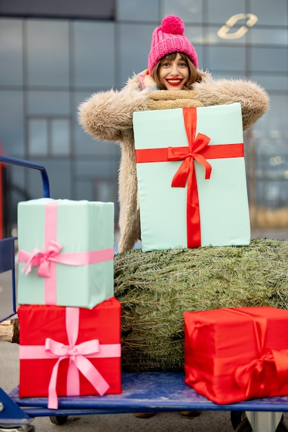 Mujer compra árbol de navidad y regalos en centro comercial