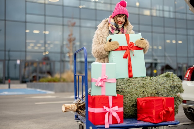 Mujer compra árbol de navidad y regalos en centro comercial