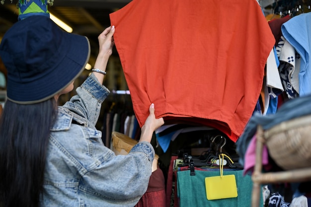 Mujer comprando camisa local en la tienda local durante las vacaciones de viaje o el tiempo de vacaciones