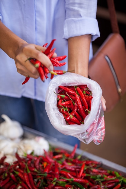 Mujer comprando chiles rojos