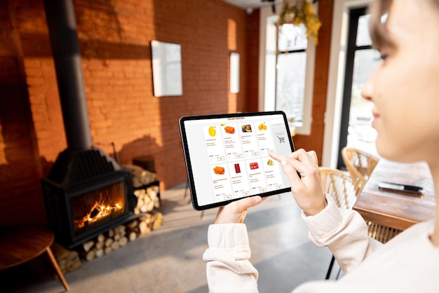 Mujer comprando comida en línea usando una tableta digital en casa